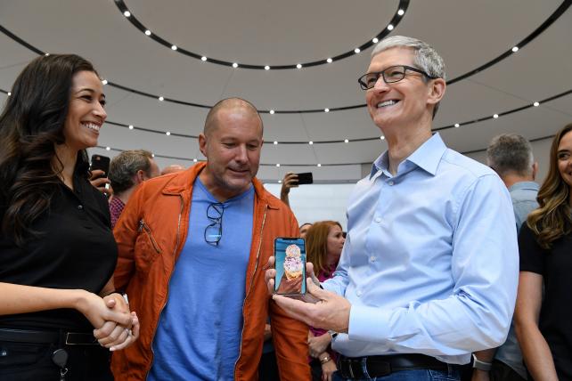 Apple Chief Design Officer Jony Ive and CEO Tim Cook view the iPhone X during an event to introduce the device at the Steve Jobs Theater in Cupertino, California, on Sept. 12, 2017.