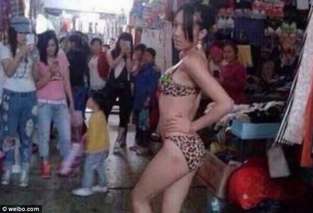 Striking a pose: The Chinese saleswoman puts a hand on her hip as she showcases her leopard print underwear