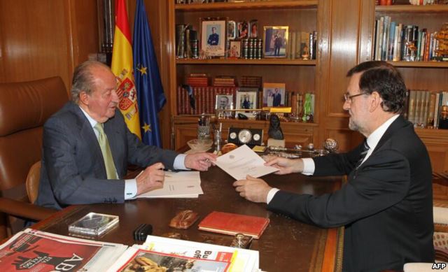 A handout photo provided on June 2, 2014 shows Spain's King Juan Carlos (L) hands over a letter of abdication to Spain's Prime Minister Mariano Rajoy at the Zarzuela Palace in Madrid.