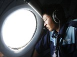 Military officer Nguyen Tran looks out from a Vietnam Air Force AN-26 aircraft during a mission to find the missing Malaysia Airlines flight MH370, off Con Dao island