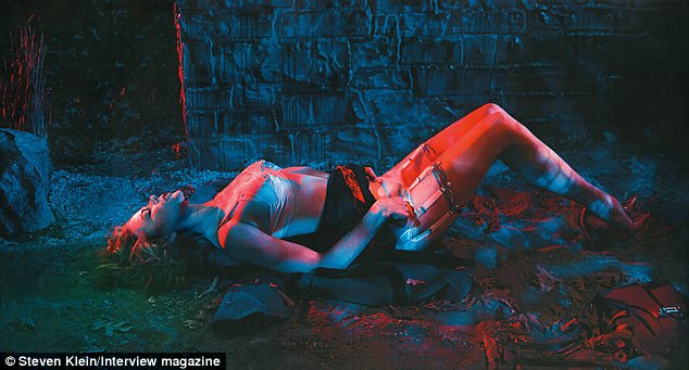 Film noir style: The 47-year-old can also be seen in suspenders, stockings and heels as she lies on the dirty ground