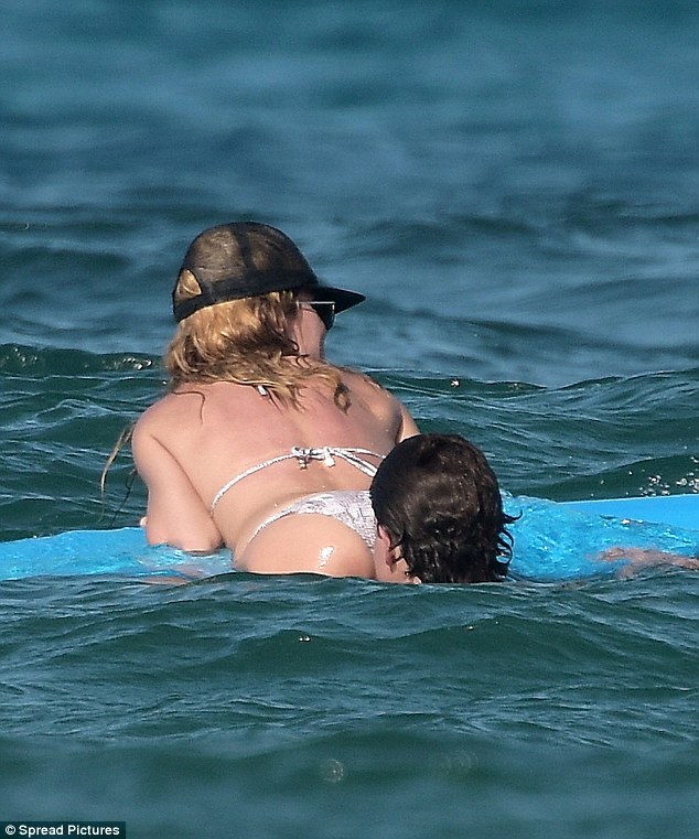 Cheeky: She soaked up some sun wearing an itsy bitsy python print two-piece while bobbing in the warm water with Vito