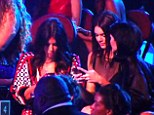 Kim Kardashian and her sisters, Kendall and Kylie Jenner, check their phones at the MTV Music Video Awards during a moment of silence for Michael Brown