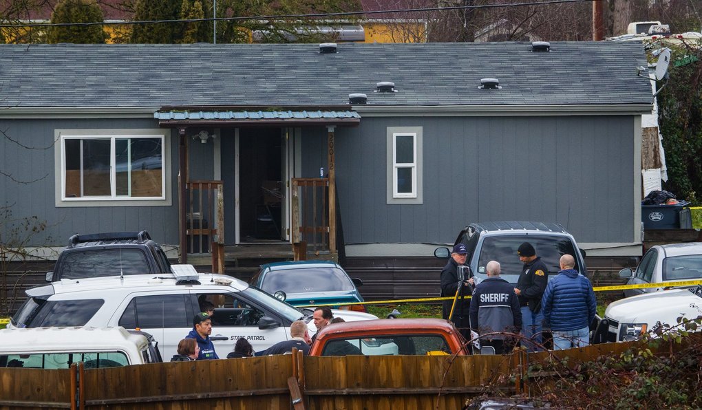 Deputy Daniel McCartney was responding to a reported home invasion at this gray house, viewed from a neighboring home.  (Ellen M. Banner / The Seattle Times)