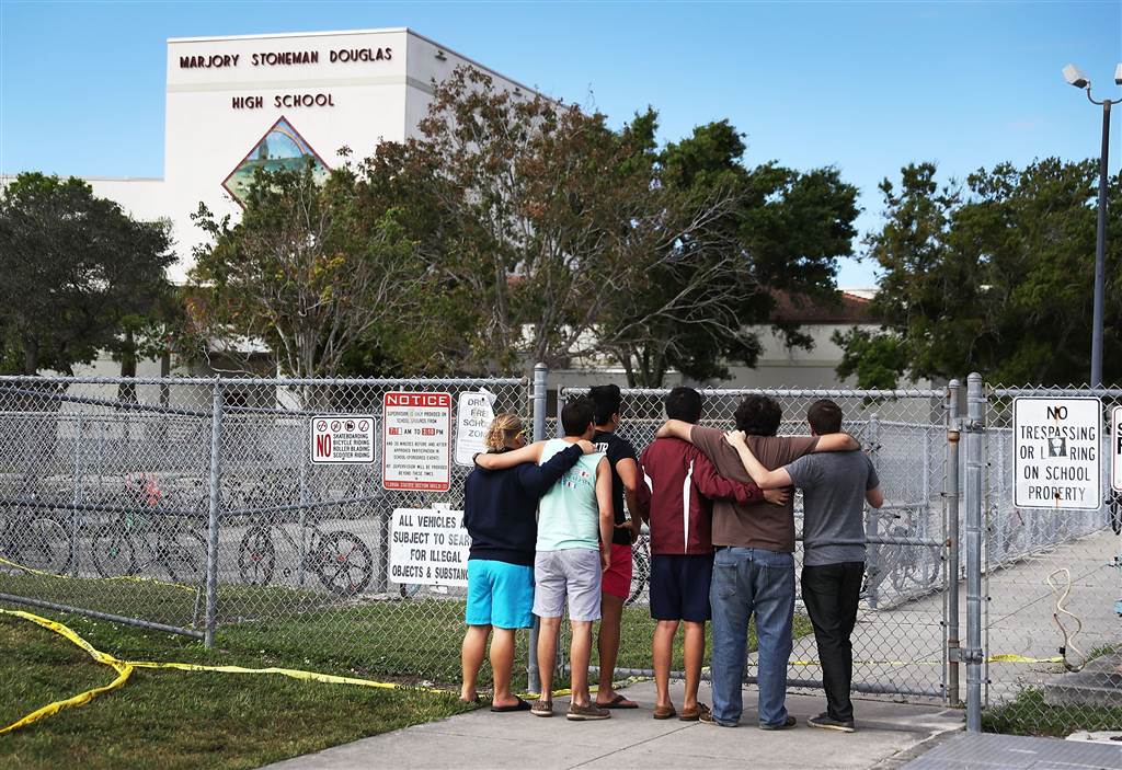 Image: People look on at the Marjory Stoneman Douglas High School