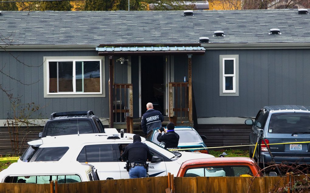 Deputy Daniel McCartney was responding to a reported home invasion at this gray house, viewed from a neighboring home.  (Ellen M. Banner / The Seattle Times)