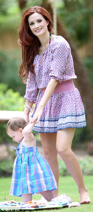 Playtime! Holly showed off her slim legs as she pushed her daughter on a wooden swing