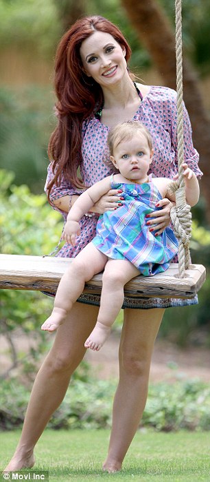 Playtime! Holly showed off her slim legs as she pushed her daughter on a wooden swing