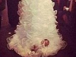 Here comes the baby: Shona Carter-Brooks decided to include her one-month-old daughter in her wedding ceremony by strapping the child into the back of her gown, which is said to be Vera Wang