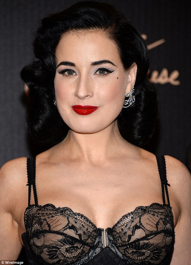 Classic beauty: The burlesque model wore her jet black locks into a wave and signature hot red slick of lipstick