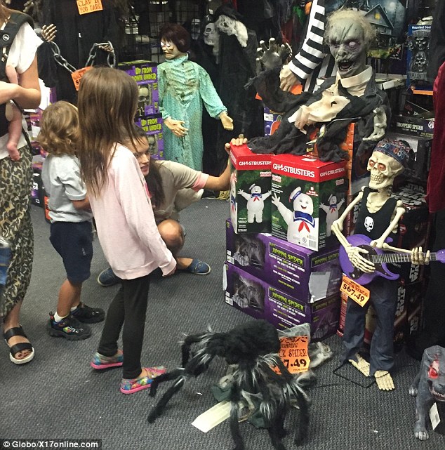 Having a blast: The family looked to be revelling in their afternoon of fancy dress shopping as they rifled through the store's creepy supplies