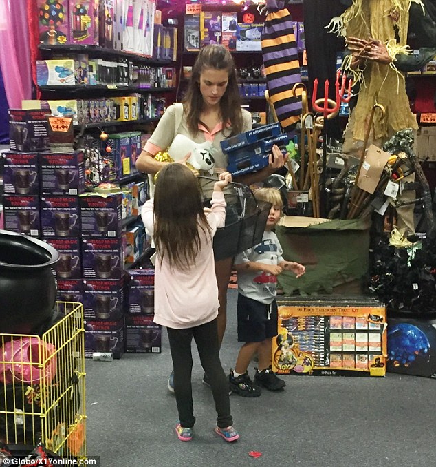 Piling it up: It looked as though money was no object during the trip as Alessandra was seen balancing a number of goodies in her arms before her daughter kindly handed her a basket