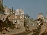 Total ruins: An army jeep drives through what is left of a French town filmed by the color camera of George Stevens