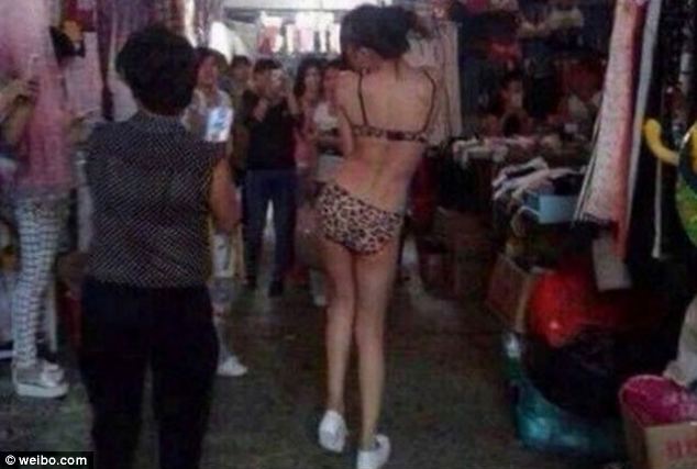 Strutting her stuff: The living mannequin, wearing a pair of white shoes to protect her feet, spins around to give shoppers another view of her leopard print outfit