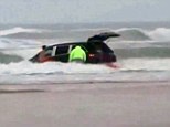 Race against time: The rescuers managed to grab all the children from the car as it was submerged in the surf