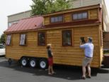 Doug McEneany, right, takes a picture as Jill Caraway, left, looks over a Tumbleweed brand Cypress 24 model Tiny House on display in Boulder, Colorado