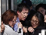 Angry family members of missing passengers onboard the capsized Sewol ferry drag Choi Sang-hwan, deputy head of the South Korean coast guard (centre, in blue), out from his office to vent their frustration at the pace of the search efforts