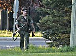 Armed and dangerous: The Royal Canadian Mounted Police tweeted an image of suspected cop killer Justin Bourque, 24, wearing military camouflage and wielding two guns