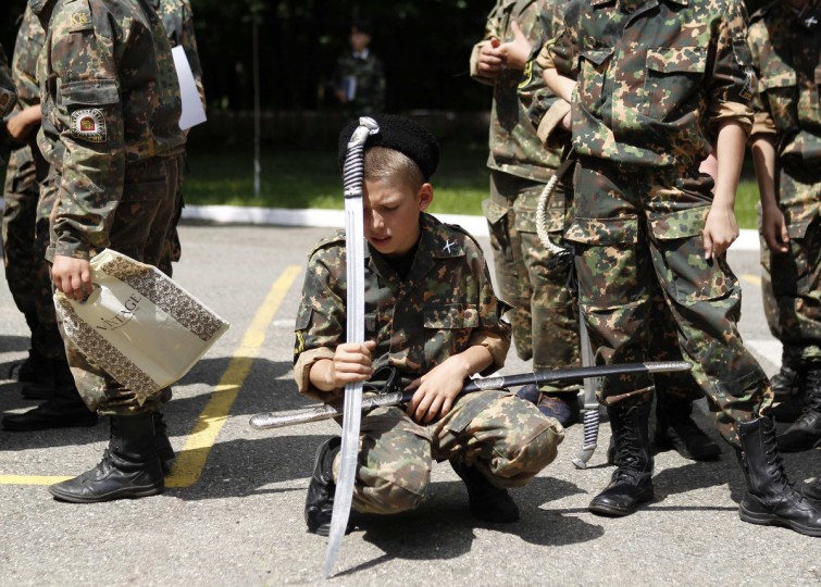 A student from the General Yermolov Cadet school rests on his sword during the Last Bell ceremony to mark the end of the school year in Stavropol. The General Yermolov Cadet School in the southern Russian city of Stavropol is a state-run institution that teaches military and patriotic classes in addition to a normal syllabus. (Eduard Korniyenko/Reuters)