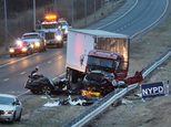 Police investigate the crash scene between a truck and a car carrying four people in the Staten Island borough of New York, Friday, March 20, 2015. The car, driving the wrong way and carrying three off-duty officers with the Linden, N.J. police department, crashed into the truck, killing one officer and another person and leaving two other officers critically injured, officials said. The truck driver was treated for injuries that weren't considered to be life-threatening. (AP Photo/Staten Island Advance, Irving Silverstein)  MANDATORY CREDIT