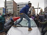 Demonstrators destroy the windshield of a Baltimore Police car as they protest the death Freddie Gray, an African American man who died of spinal cord injuries in police custody, in Baltimore, Maryland, April 25, 2015. Protesters returned to Baltimore's streets Saturday to vent outrage over the death of Gray on April 12.      AFP PHOTO/JIM WATSON        (Photo credit should read JIM WATSON/AFP/Getty Images)