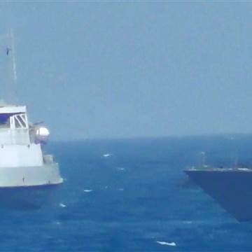 Image: Iranian vessel steers close to the U.S. Navy coastal patrol craft USS Thunderbolt in the Gulf i