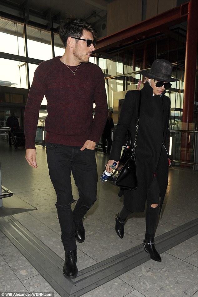 Jet-set style: Rita opted for an uncharacteristically low-key look as she headed through Heathrow Airport alongside her handsome hairdresser Chris Appleton earlier that day