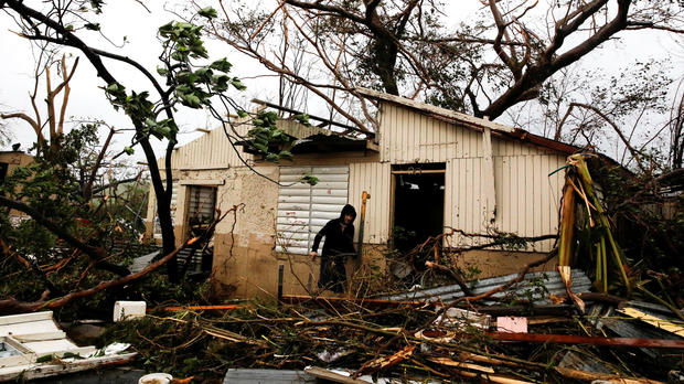 A man looks for valuables in the damaged house of a relative after the area was hit by Hurricane Maria in Guayama, Puerto Rico, Sept. 20, 2017. 