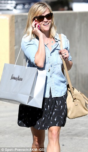 Fashion forward: The 38-year-old looked casual, comfy and chic in a blue denim shirt over a floaty black mini-skirt with a white fleck pattern