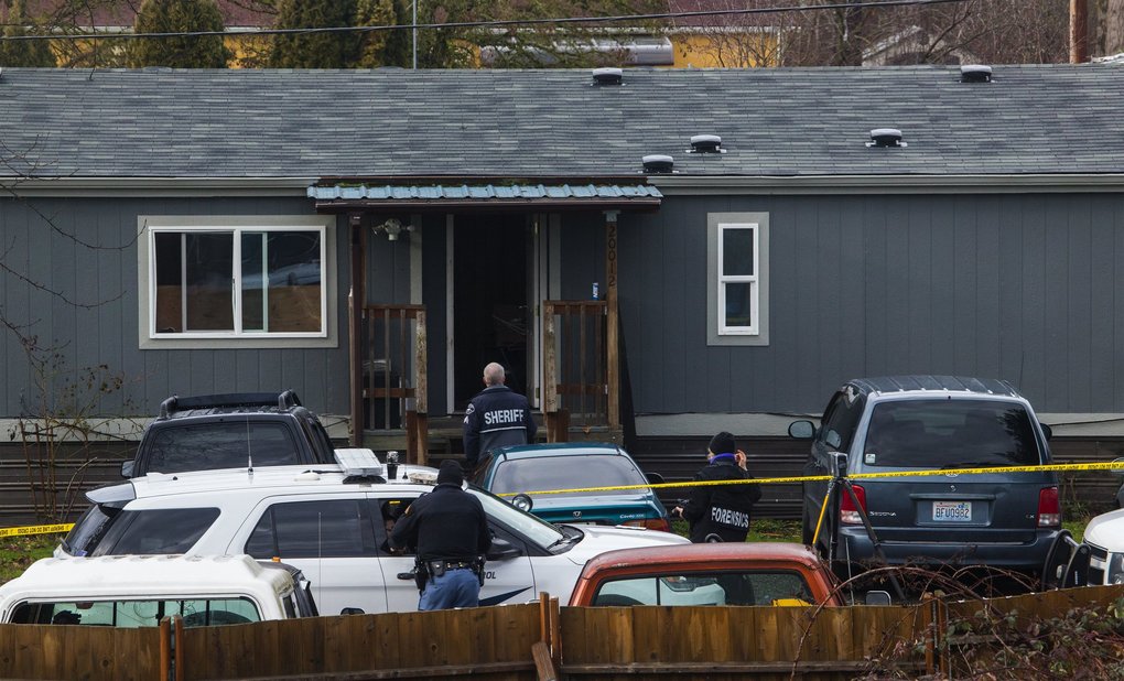 Deputy Daniel McCartney was responding to a reported home invasion at this gray house, viewed from a neighboring home.  (Ellen M. Banner / The Seattle Times)