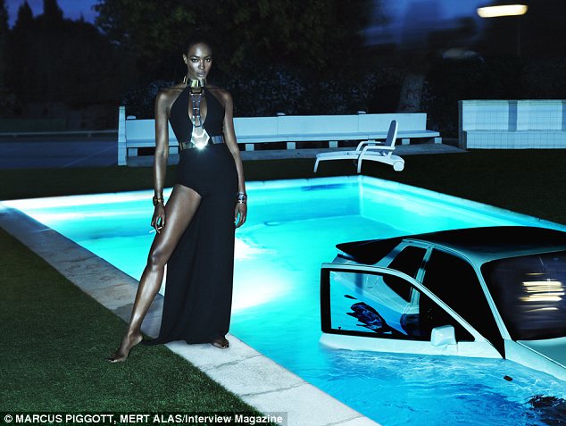 Wild thing: The supermodel then stands beside a pool with a car in it while wearing a saucy split dress