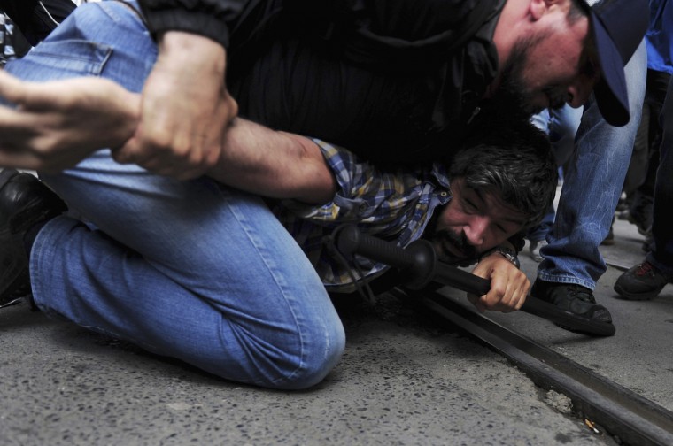 A plainclothes police officer detains a demonstrator during a protest in central Istanbul. Turkish police fired teargas and water cannon on Saturday to disperse protesters in central Istanbul who sought to mark the one-year anniversary of the country's biggest anti-government demonstrations in decades. (Yagiz Karahan/Reuters)