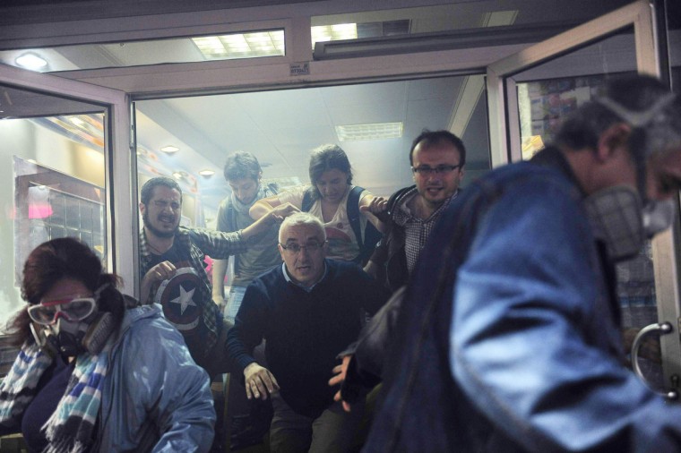 People try to escape from a cafe, after tear gas fired by riot police outside to disperse protesters seeped in, at central Istanbul. Turkish police fired teargas and water cannon on Saturday to disperse protesters in central Istanbul who sought to mark the one-year anniversary of the country's biggest anti-government demonstrations in decades. (Yagiz Karahan/Reuters)