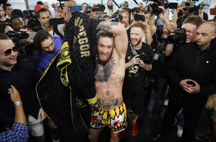 Conor McGregor puts on his robe after a workout in front of the media, Friday, Aug. 11, 2017, in Las Vegas. McGregor is scheduled to fight Floyd Mayweather Jr. in a boxing match Aug. 26 in Las Vegas. (AP Photo/John Locher)