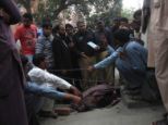 Police collect evidence near the body of Farzana Parveen, who was killed after being set upon by members of her own family outside a court in Lahore