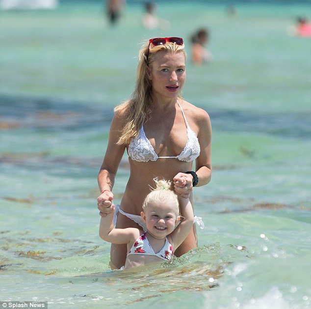 Doting: The tot grinned from ear to ear as she played in the surf with her mum