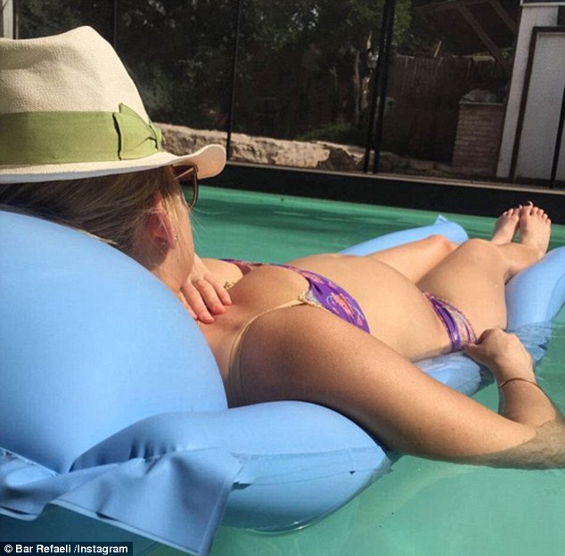 Relaxing in style: Bar, who is expecting her first child with husband Adi Ezra, was showing off her growing baby bump in a purple bikini in her latest social media snap earlier in April