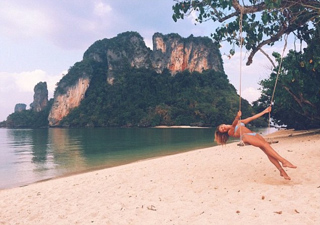 Care free: The 27-year-old let her hair down as she swung barefoot on the deserted beach