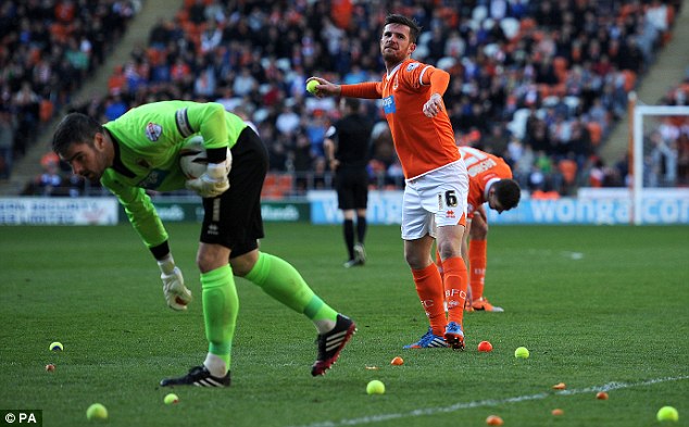 Blackpool player manger Barry Ferguson throws back tennis ball's thrown onto the pitch by fans during the Sky Bet Championship match at Bloomfield Road, Blackpool. PRESS ASSOCIATION Photo. Picture date: Friday April 18, 2014. See PA Story SOCCER Blackpool. Photo credit should read: Martin Rickett/PA Wire. RESTRICTIONS: Editorial use only. Maximum 45 images during a match. No video emulation or promotion as 'live'. No use in games, competitions, merchandise, betting or single club/player services. No use with unofficial audio, video, data, fixtures or club/league logos.