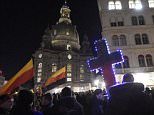 Demonstrators hold an illuminated cross and German flags upside-down during a demonstration of PEGIDA (Patriotic Europeans against the Islamization of the West) in Dresden, eastern Germany, Monday, Nov. 2, 2015. (AP Photo/Jens Meyer)