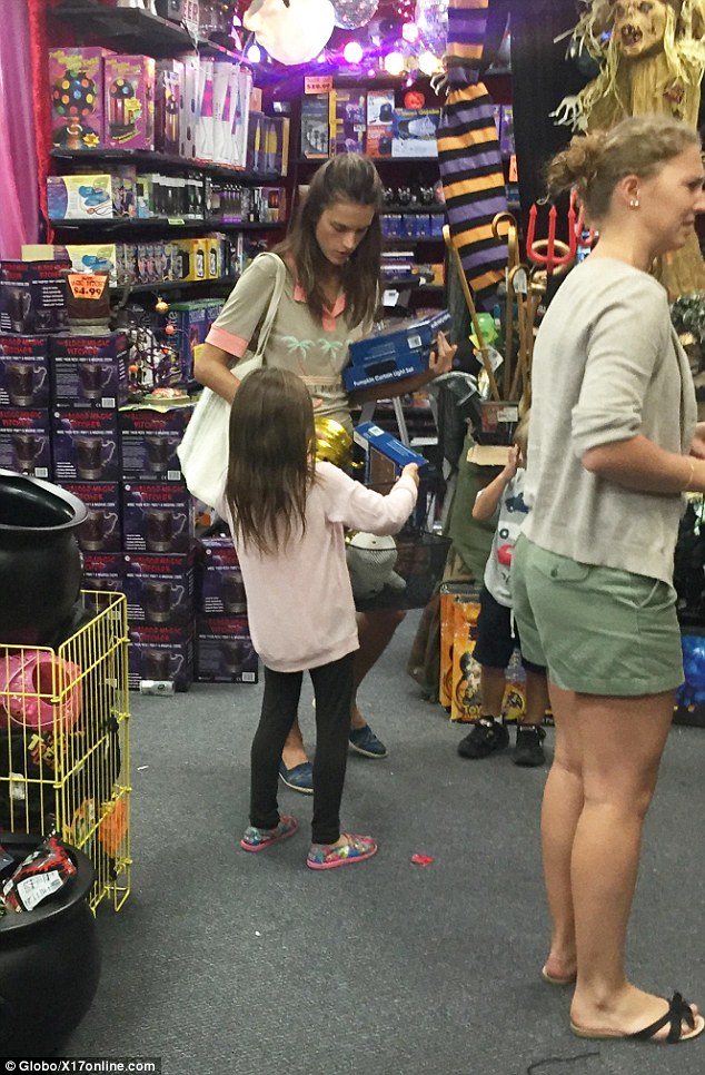 Splashing the cash: Alessandra appeared to be running out of hands as she attempted to balance her basket against her knee while stocking it with goodies