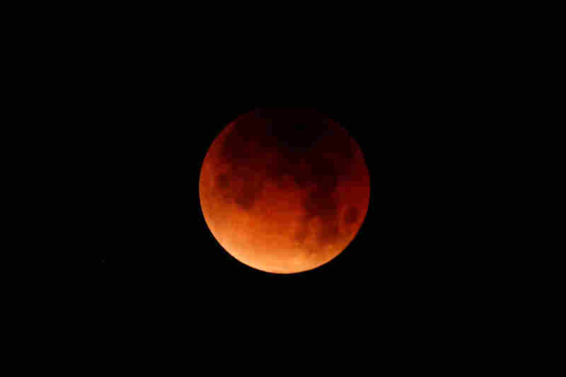 A lunar eclipse is shown over the ocean in Oceanside, Calif.