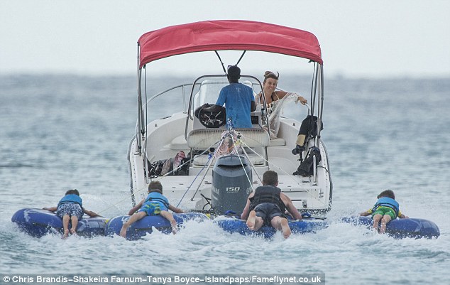 Having a giggle: She kept an eye over her boy and his pals as they all clung onto their rubber rings