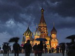 02 Jun 2012, Moscow, Russia --- Sightseers with umbrellas on a wet evening in Red Square. --- Image by © Jon Hicks/Corbis