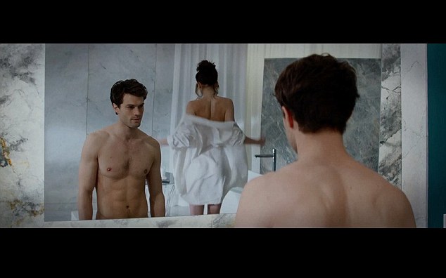 Jamie Dornan as Christian Grey admires Anastasia in the mirror in the movie out next month