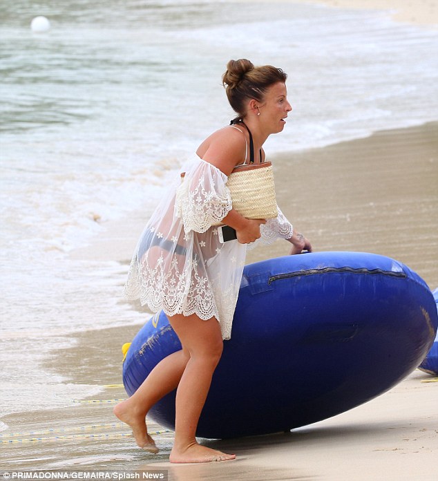 Knows what she's doing: Coleen expertly juggled a clutch bag, iPhone and huge inflatable 